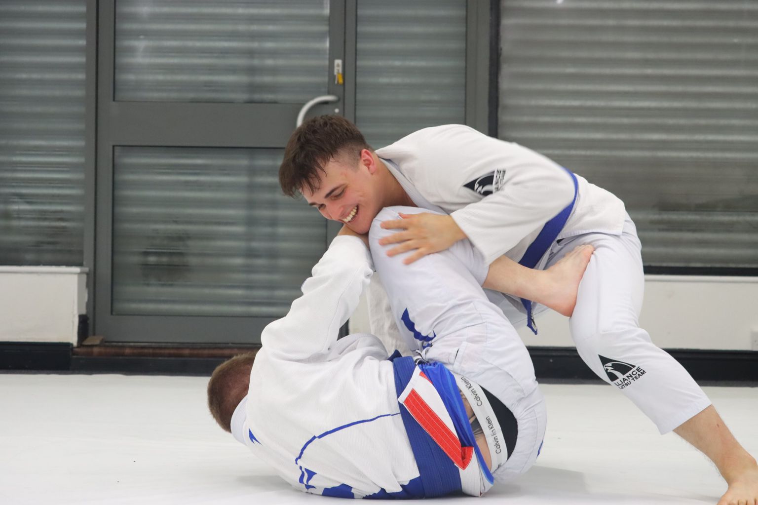 Two jiu jitsu practioners rolling and sparring in guard